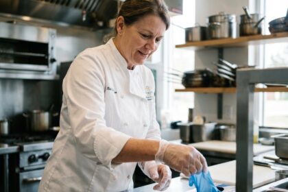 Femme en cuisine avec gants jetables en main